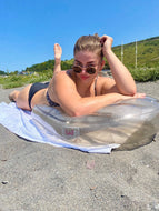woman sunbathing on a beach laying on breast support pillow in comfort